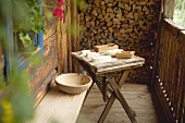 Bauernbutter und Holzmodeln auf einfachem Holztisch vor einer Berghütte