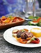 Plate of grilled meat & peppers with potatoes & tzatziki