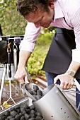 A man shovelling coal into a metal bucket