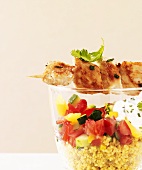 Chicken kebab over glass of couscous