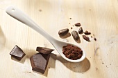 Kakaopulver, Kakaobohnen und Schokoladenstücke