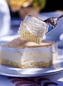A piece of creamy cheese cake on a fork