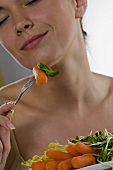 Young woman vegetables on a fork