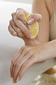 Woman squeezing lemon juice onto her hand