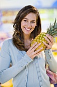 Young woman with pineapple in a supermarket