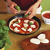 Pizza Margherita zubereiten (mit Basilikum belegen)
