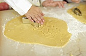 Child's hand cutting out biscuit