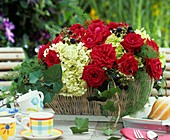 Korb mit roten Rosen, Hortensien und Brombeerranken