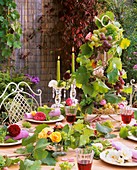 White, yellow, pink & red roses with grapes as table decoration