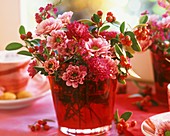 Chrysanthemums and cotoneaster in vase