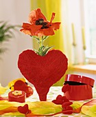 Red poppy in heart-shaped vase