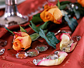 Orangefarbene Rose mit Efeu und Glaskristalle