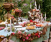 Gedeckter Tisch mit Apfelkuchen, Granatäpfeln und Feigen