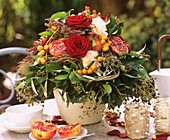 Autumn arrangement of roses, pomegranates and dates