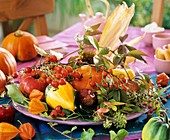 Herbstliche Tellerdeko mit Hagebutten und Zierkürbissen