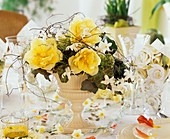 Tischdeko mit Gesteck aus Tulpen, Efeu und Schneeball, dekoriert mit Girlande aus Hyazinthenblüten