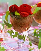 Red Ranunculus with ivy and sisal in wine glass