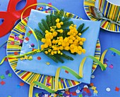 Mimosa on cake plate with confetti and paper streamers
