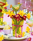 Place-setting with Easter eggs, posy of narcissi and daisies