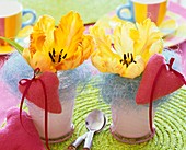 Gelbe Tulpen mit blauem Sisal und rosa Filzherzen