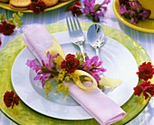 Place-setting decorated with Stachys, lady's mantle & carnation
