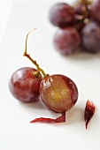 Rote Weintrauben, eine halb geschält