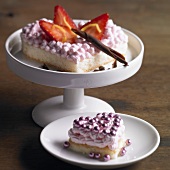 Two heart-shaped sponge cakes with strawberry cream, chocolate, dragees