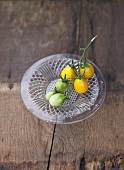 Ripe and unripe yellow plum tomatoes on glass plate