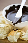 A small bowl of chocolate sauce with baguette