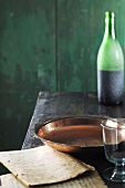 Copper dish, bottle of wine and old exercise books