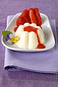 Moulded cream dessert with strawberries and strawberry sauce