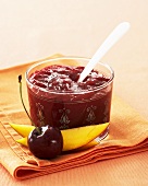 Cherry and mango jam in jar with spoon