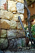 Wire hare figure by stone wall