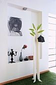 DIY coat rack in front of photograph on wall of niche