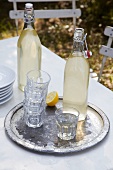 Two bottles of lemonade and glasses on a tray