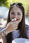 Young woman eating tomato and goat cheese crostini