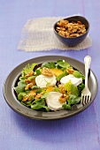 Salad leaves with goat's cheese, orange segments, walnuts and mint