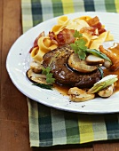 Steak with mushroom sauce, noodles and bacon