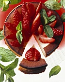 Cheesecake topped with strawberries and mint leaves