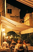 Terrace of a French restaurant in historic city setting at dusk