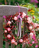 Wreath of roses and rose hips tied to a chair back