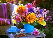 Autumnal arrangement of dahlias and asters on garden table
