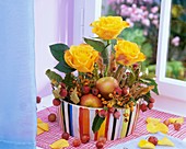 Arrangement of yellow roses, crab apples, apples & autumn leaves