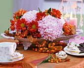 Chrysanthemums and Oriental bittersweet fruits in bowl