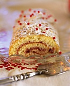 Decorated sponge roll filled with strawberry jam