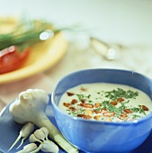 Garlic soup with croutons, chilli and herbs