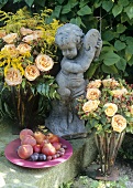 Garden decoration: roses, plate of fruit and stone figure