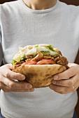 Hands holding a döner kebab