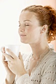 Red-headed woman appreciating a cup of tea