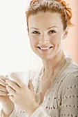 Red-headed woman holding a teacup